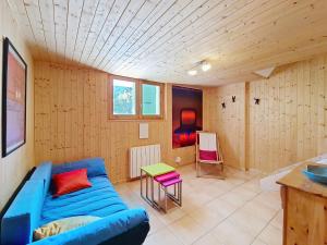 a living room with a blue couch and a table at Chalet Casimir CSM CHARMING & NATURE 10 Pers in Châtel