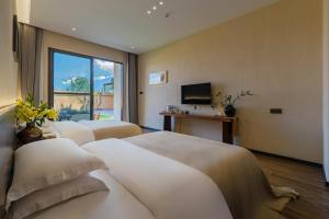 Ένα ή περισσότερα κρεβάτια σε δωμάτιο στο Dali Buxi Traditional Chinese Medicine Wellness and Spiritual Retreat Villa Mountain and Sea Homestay +40 φωτογραφίες