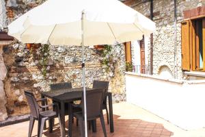 una mesa y sillas con una sombrilla en el patio en Casa Vacanze Antico Poggio, en Poggio San Giovanni