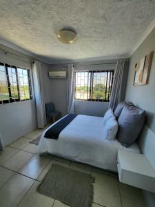 ein Schlafzimmer mit einem großen Bett und zwei Fenstern in der Unterkunft Casabella Macaneta in Marracuene + 43 Fotos