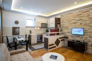 ein Wohnzimmer mit Couch und Küche in der Unterkunft City Apartments Premium in Trebinje