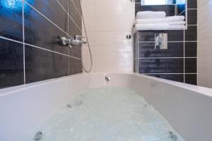 eine Badewanne in einem Badezimmer mit Dusche in der Unterkunft City Apartments Premium in Trebinje