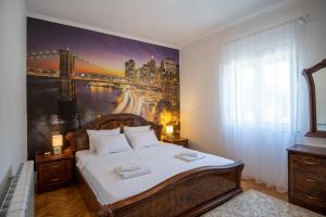 ein Schlafzimmer mit einem großen Gemälde an der Wand in der Unterkunft City Apartments Premium in Trebinje