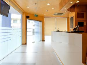 an office lobby with a white counter and a tv at Hotel 81 Fuji in Singapore