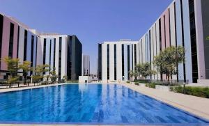 una gran piscina frente a dos edificios altos en Stunning Studio in Solo 1 By Arada, en Sharjah