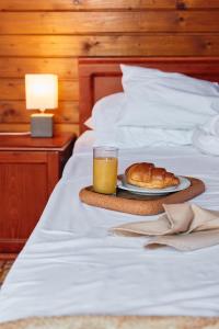 a plate of bread and a glass of orange juice on a bed at Egri Korona Borház és Wellness Hotel in Demjén