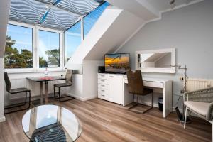 an attic living room with a desk and a tv at Villa Strandidyll Apartment 15, Meerblick, inkl Strandkorb in Binz