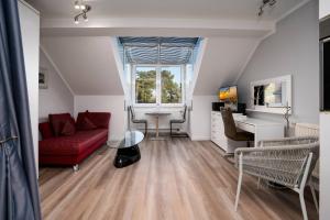 a living room with a red couch and a desk at Villa Strandidyll Apartment 15, Meerblick, inkl Strandkorb in Binz
