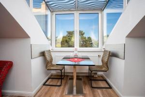 a dining room with a table and a window at Villa Strandidyll Apartment 15, Meerblick, inkl Strandkorb in Binz +8 photos