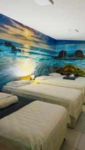 três camas num quarto com um quadro na parede em Casa da Keka em Noronha em Fernando de Noronha mais 28 fotografias