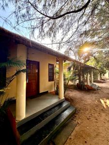 a small house with stairs leading to a door at Barefoot and Beyond - Crafted with Kenchas in Gokarna