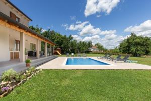 a backyard with a swimming pool and lawn at Villa Flora in Kršan