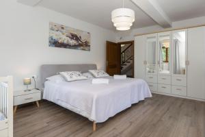 a white bedroom with a bed and a mirror at Villa Flora in Kršan +30 photos