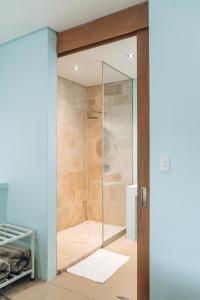 a glass shower door in a bathroom at The Village Suites in Windhoek