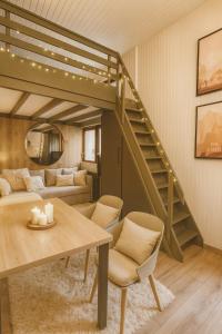 - un salon avec une mezzanine et une table dans l'établissement Ma Montagne Chic 4, à La Bresse