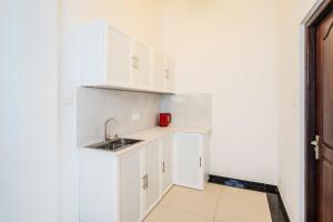 a kitchen with white cabinets and a sink at Uyanawatta villa talpe in Talpe