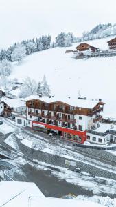 Una estación de tren en la nieve con edificios cubiertos de nieve. en Hotel Fernblick, en Bresanona