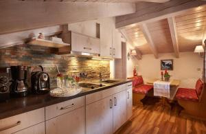 a kitchen with white cabinets and a counter top at Landhaus Kränzle in Fischen