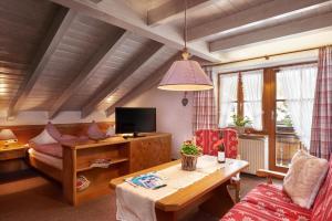 a living room with a couch and a table and a tv at Landhaus Kränzle in Fischen