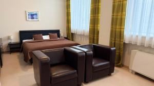 a bedroom with a bed and a leather chair at Aston Hotel in Bratislava