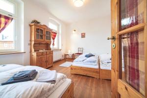 a bedroom with two beds and a wooden door at Körnermühle in Dippoldiswalde