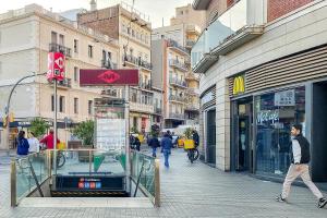 een man die door een straat naast een winkel loopt bij Centric Apartment Camp Nou 2 in Hospitalet de Llobregat
