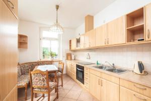 a kitchen with wooden cabinets and a table and a sink at Körnermühle in Dippoldiswalde