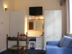 a living room with a blue couch and a mirror at Mermaid Suite Hotel in London