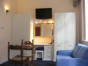 sala de estar con sofá azul y espejo en Mermaid Suite Hotel, en Londres