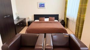 a bedroom with a bed and a couch at Aston Hotel in Bratislava