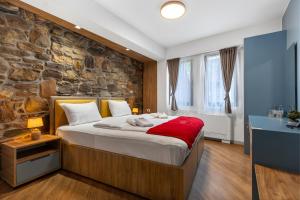 a bedroom with a large bed with a stone wall at Old Stone Hotel Skopje in Skopje