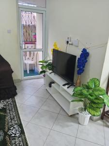 ein Wohnzimmer mit einem Flachbildfernseher auf einer Couch in der Unterkunft Lovely 2- Bedroom unit Near Diani Beach in Ukunda