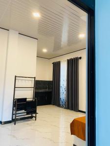 a bedroom with a bed and a chair and a window at Abi Restaurant & Villa in Tangalle