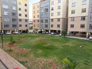 Crystal Rivers Apartments في Athi River: منطقة عشبية في وسط مبنيين