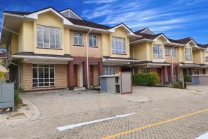 Crystal Rivers Apartments في Athi River: منزل أصفر كبير مع موقف للسيارات