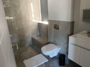 a small bathroom with a toilet and a sink at Simons Town long beach Penthouse in Simonʼs Town +3 photos