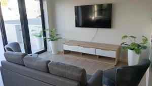 a living room with a couch and a flat screen tv at Simons Town long beach Penthouse in Simonʼs Town