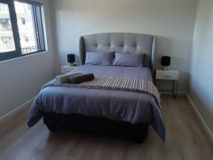 a bedroom with a large bed with purple pillows at Simons Town long beach Penthouse in Simonʼs Town