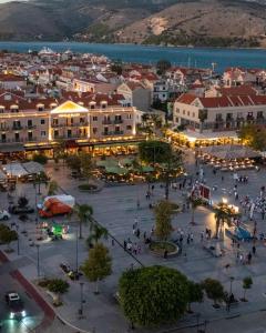 un gruppo di persone che camminano per una città con le luci di Tilde by the square, apt Argostoli ad Argostoli