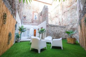 a courtyard with a table and chairs on green grass at La Villa Lova - Loveroom avec spa privatif à Pamiers in Pamiers