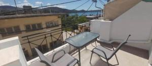 un balcone con tavolo e sedie su un cornicione di Tilde by the square, apt Argostoli ad Argostoli