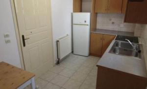 una cucina con un frigorifero bianco e un lavello di Tilde by the square, apt Argostoli ad Argostoli