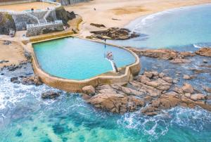 a person is standing in a swimming pool in the ocean at Joli duplex a Saint-Quay a deux pas de la plage in Saint-Quay-Portrieux