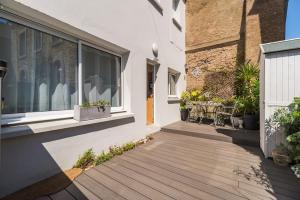 a house with a wooden porch with a window at Joli duplex a Saint-Quay a deux pas de la plage in Saint-Quay-Portrieux