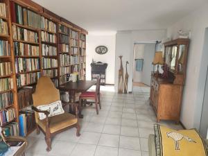 una sala con una biblioteca con estanterías llenas de libros en BeachHome 1 min from sea on private beach, en Groot Brak Rivier