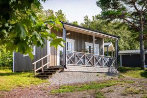 a small house with a porch and stairs to it at Visby Strandby in Visby