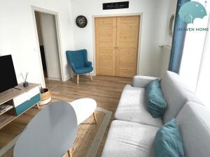 ein Wohnzimmer mit einer weißen Couch und einem blauen Stuhl in der Unterkunft Agreable T2 proche des commerces et gare in Saint-Brieuc + 5 Fotos