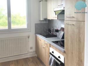 eine Küche mit Holzschränken und einem Herd mit Backofen in der Unterkunft Agreable T2 proche des commerces et gare in Saint-Brieuc