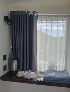 塞姆博伦拉旺Villa Miradarma的一扇挂着蓝色窗帘的窗户，窗外摆着一张放着餐具的桌子。 更多13张照片