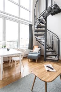 a living room with a spiral staircase and a table at Biz Apartment Hammarby Sjöstad in Stockholm